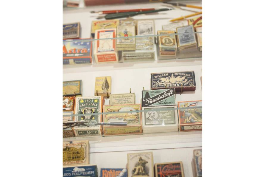 Viele verschiedene Schachteln von Schreibfedern sind in einem Regal aufgestellt.