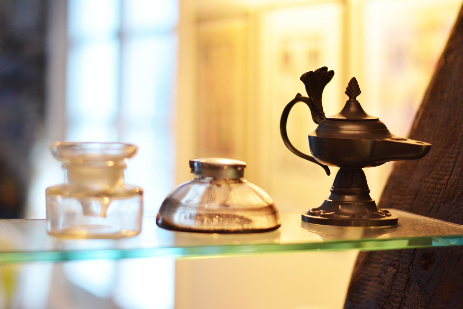 Auf einer Glasplatte stehen 3 alte Gefäße für Tinte.