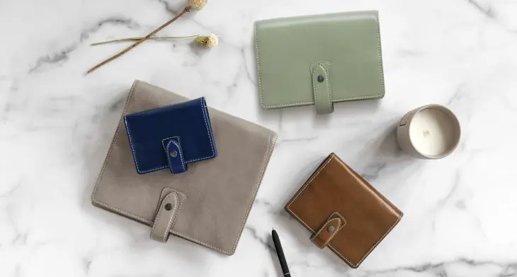 Auf einem Marmortisch liegen Planer von Filofax in unterschiedlichen Formaten und Farben