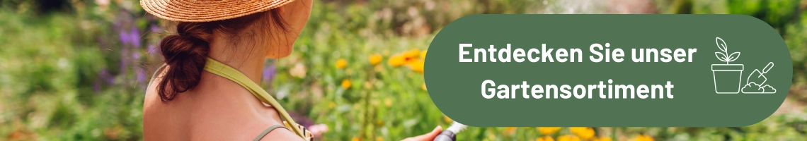 Eine Frau giest Blumen im Garten mit einem Gartenschlauch.