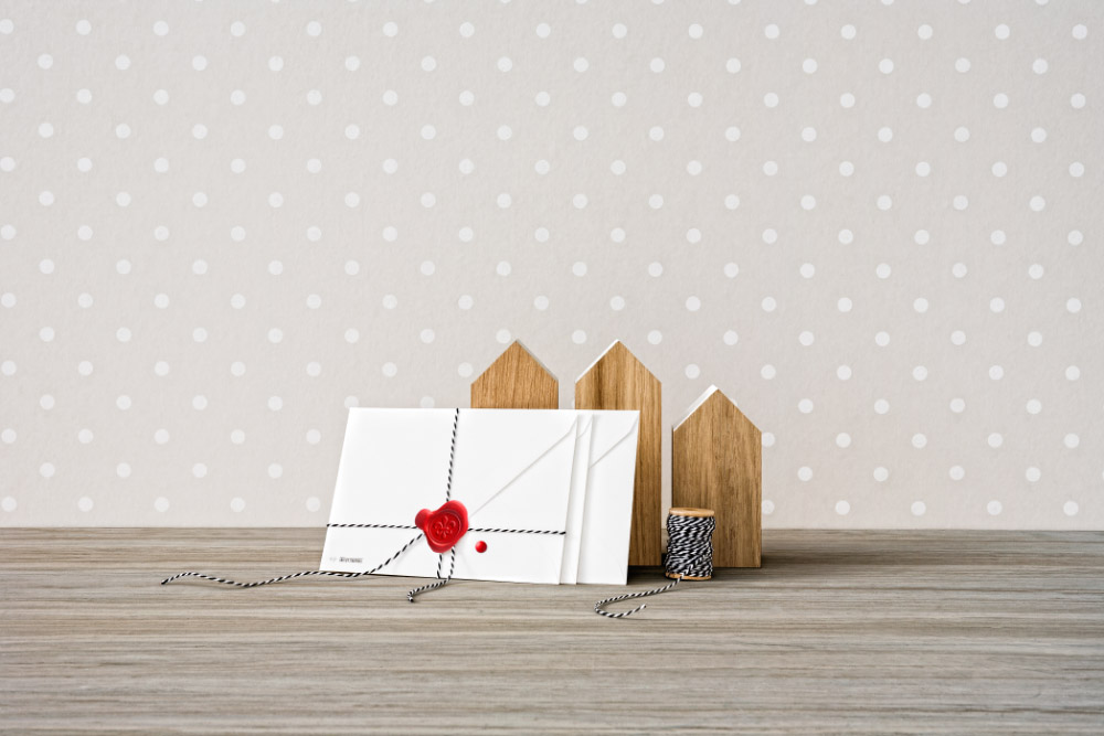 Auf einem Holztisch liegen 2 weiße Briefe, welche mit einem roten Briefsigel verschlossen wurden. 