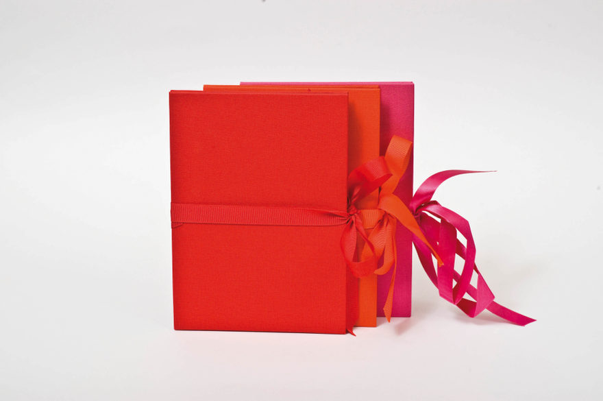 Rote Semikolon Foto-Leporellos sind auf einem Tischaufgestellt.