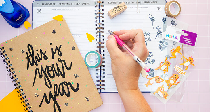 Jemand gestaltet die Innenseiten eines Schülerkalenders von BRUNNEN mit Kreativmaterialien von HEYDA und KNORR prandell. Foto: Johanna Rundel