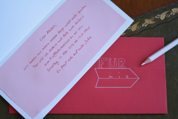 Einen Einladungskarte, die mit dem Computer geschrieben wurde. Der rote Umschlag wurde belettert.