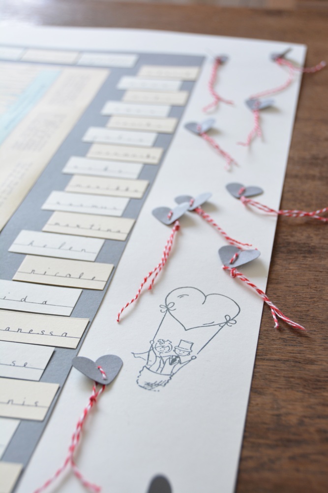 Aus Pappe gestanzte Herzen, Zeichnung eines Brautpaares auf einem Sitzplan.