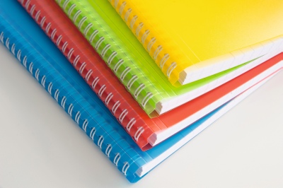 Mehrere farbige Koverbook Hefte der Marke Clairefontaine liegen übereinander gestaplet, man sieht den Einband.