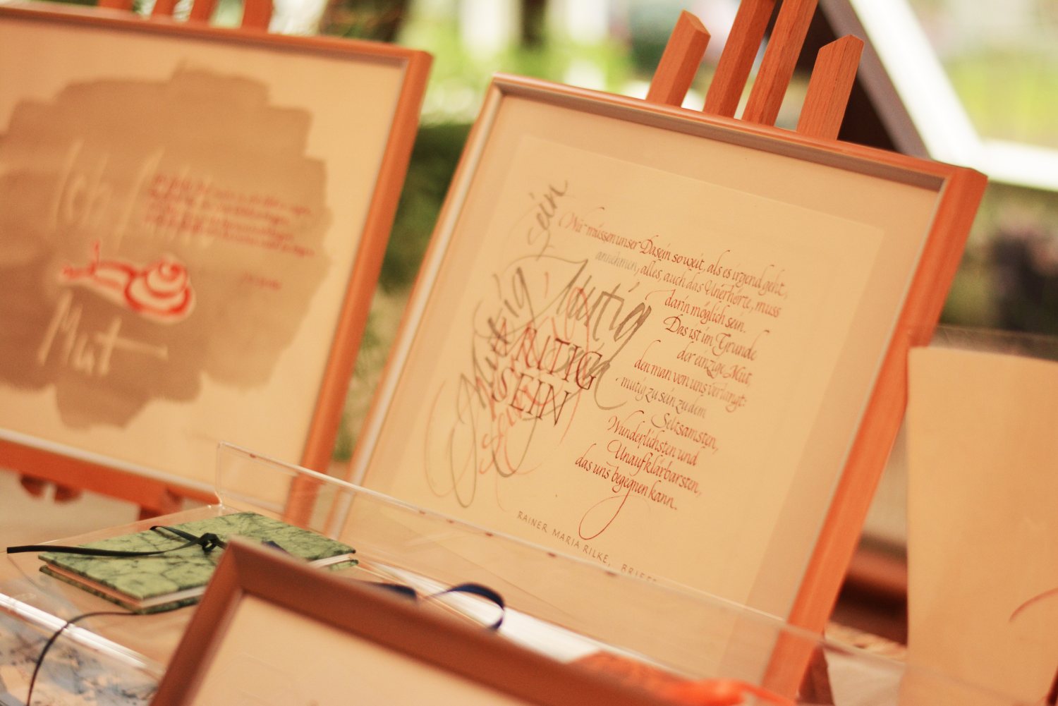 In einem Bilderrahmen auf einem Tisch ist ein Blatt mit vielen Kalligrafie-Schriftzügen eingerahmt.