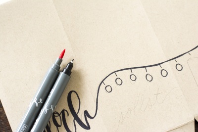 Brushpens auf beschriftetem Papier mit gezeichneter Lichterkette.