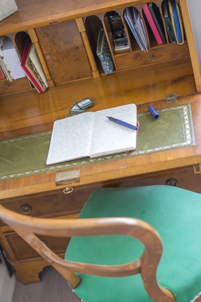 Auf einem alten Sekretär liegt ein offenes Tagebuch mit Füller.