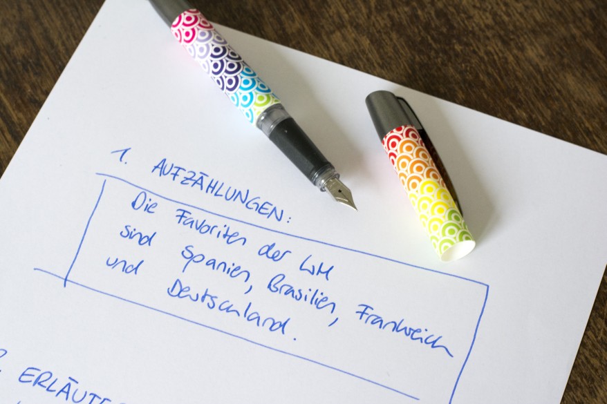 Notizen zum Thema Aufzählungen auf einem Blatt, daneben liegt ein geöffneter Füller der Marke Online.