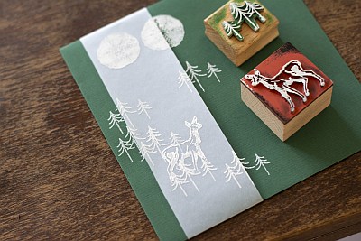 Grüne Weihnachtskarte mit Transparentpapier und gestempeltem Waldmotiv mit Rehen.
