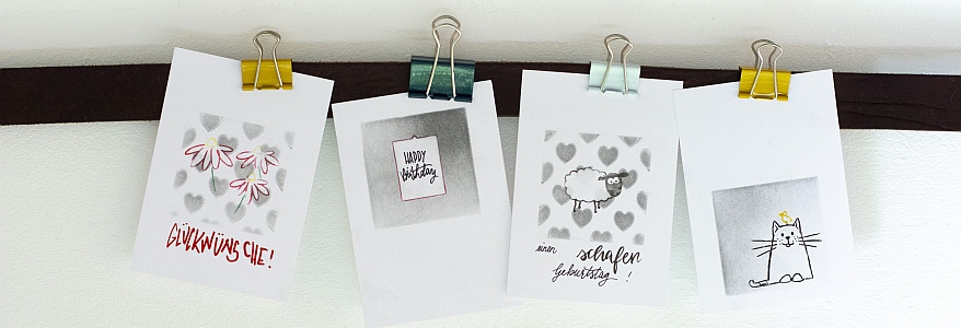 Gestempelte Karten sind mit einem  Clip an einer Leiste befestigt.