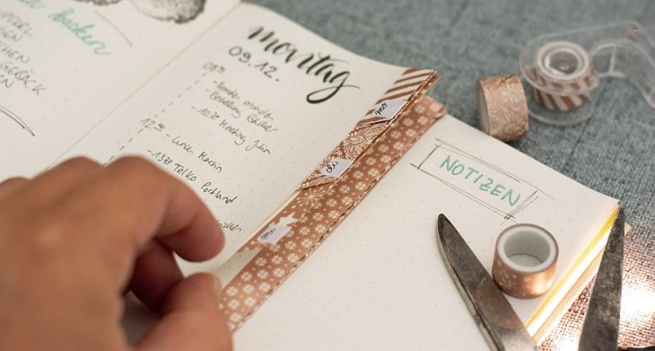Hand faltet Washi-Tape-Tabs im Bullet Journal mit Notizenseite
