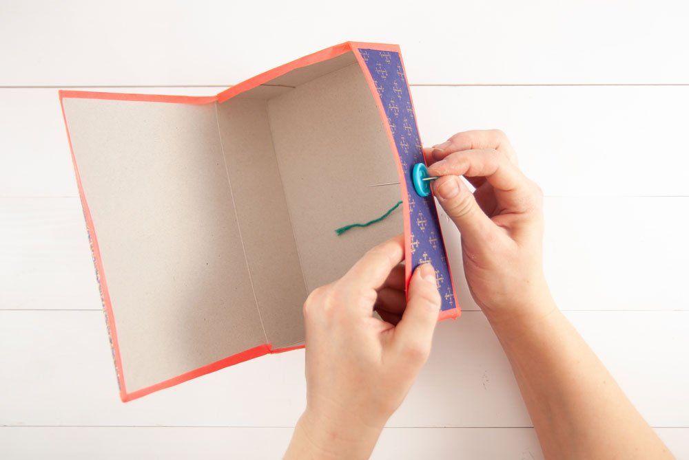 Knopf wird als Verschluss an selbstgebastelter DIY-Box befestigt