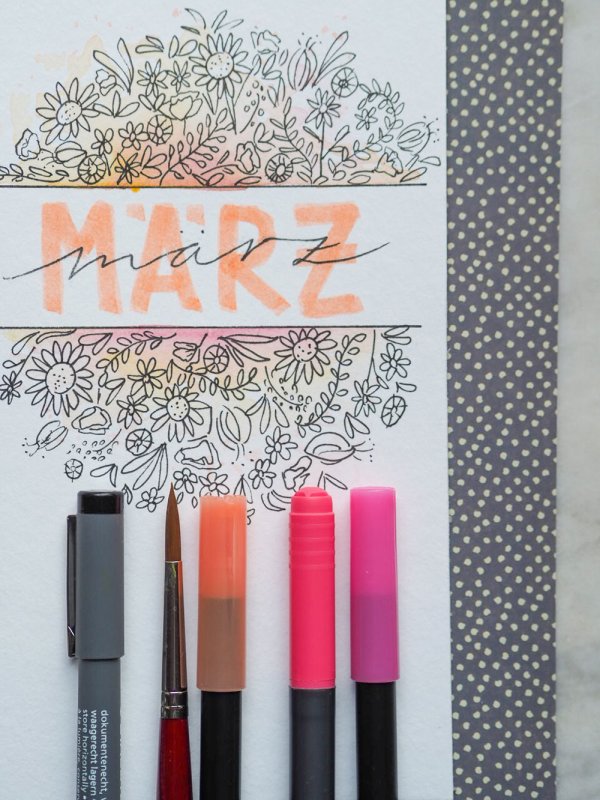 Märzschriftzug im Bullet Journal mit Blumenzeichnung und Stiften