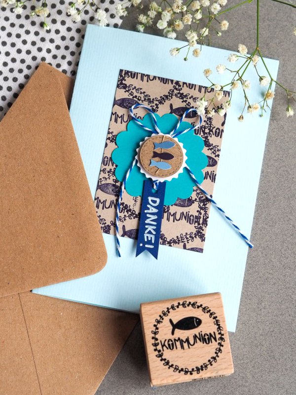 Handgemachte Dankeskarte zur Kommunion mit Fischmotiv, Schleife und Stempel.