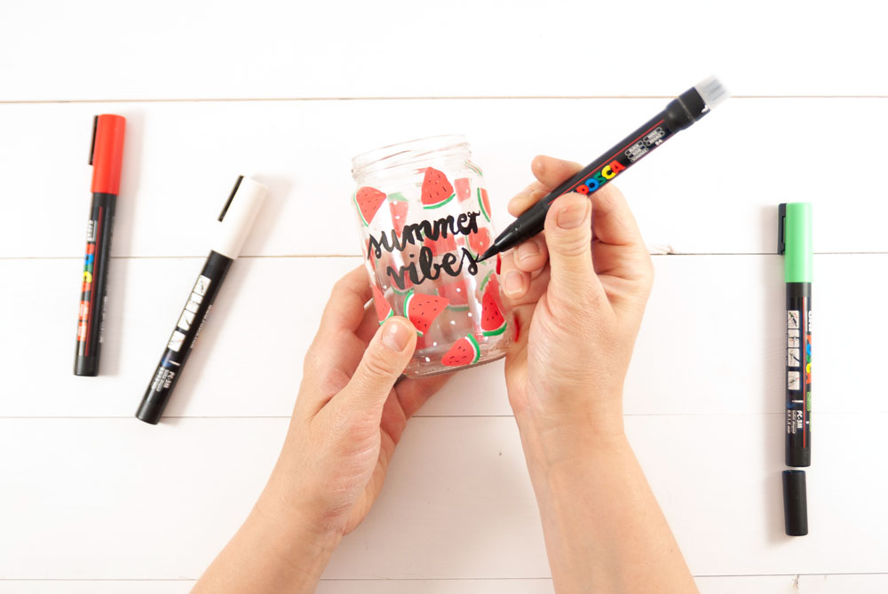 Auf ein Glas mit Melonenmuster wird der Spruch "summer vibes" gelettert