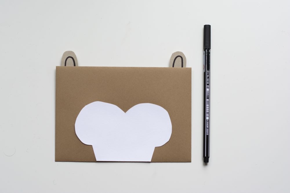 Bastelanleitung Einladungskarte zum Kindergeburtstag: Selbst gebastelte Do it yourself-Karte als Otter: Papierzuschnitte sind auf Briefumschlag geklebt.