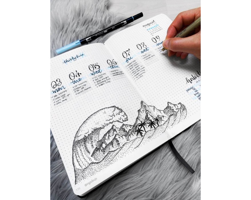 Nahaufnahme eines Bullet Planners, in dem Wellen und Berge mit der Zeichentechnik Dotwork gemalt sind.