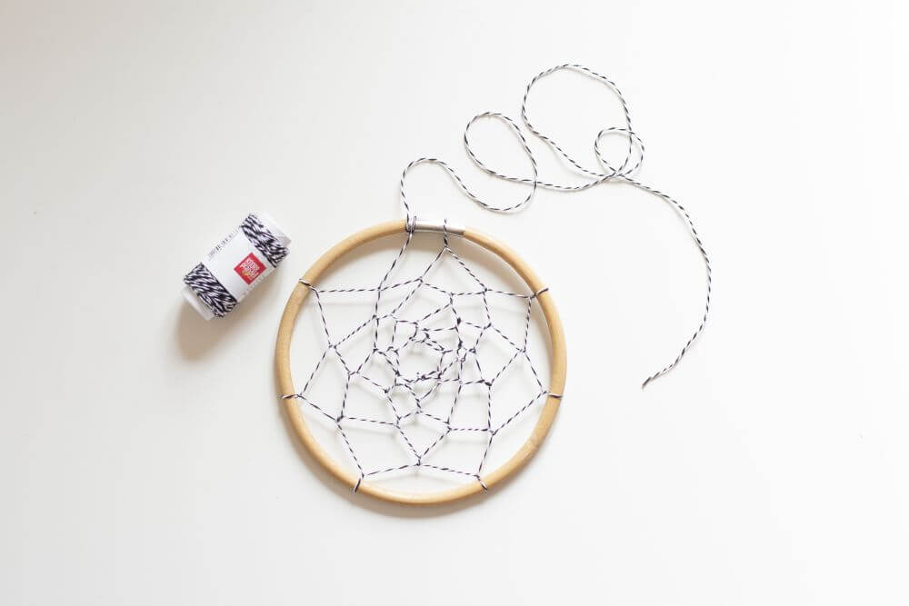 Bastelanleitung Do it yourself-Traumfänger für Kinder basteln. Schritt 1: Aus Dekoschnur wird ein Netz in einen Holzring geknüpft.