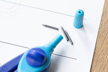 Nahaufnahme des Schulzirkels griffix von Pelikan, bei dem die Ersatzminen und der Spitzer sich im Griff befinden.