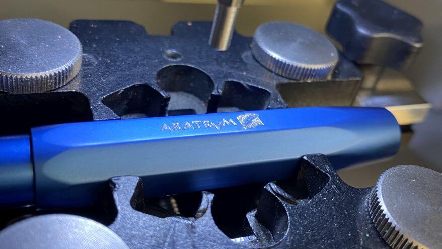Ein Füllhalter der Marke Kaweco wird in der Graviermaschine mit dem Schriftzug "Aratum" graviert.