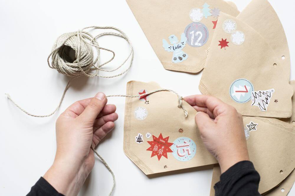Die mit Weihnachtsmotiven gestalteten Kaffeefilter werden mit einer Kordel verschlossen.