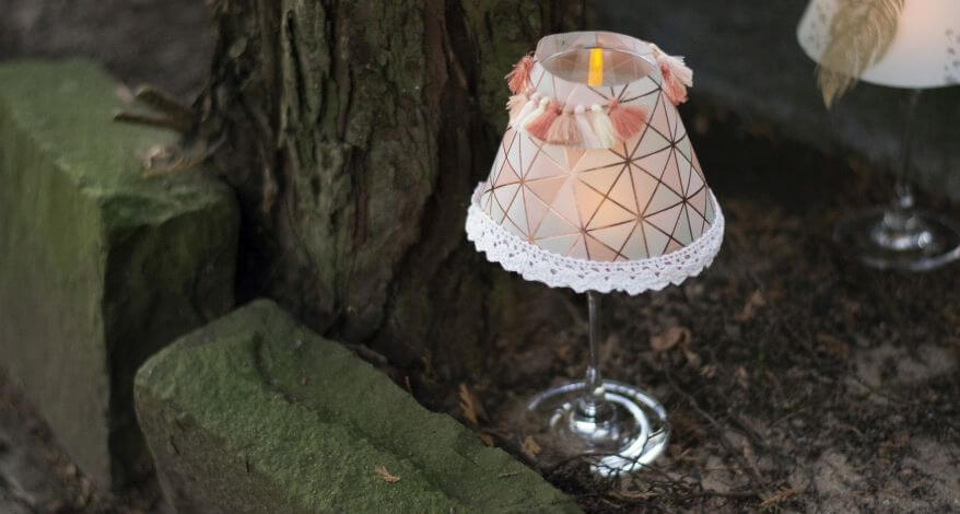 Selbstgebastelter Lampenschirm auf einem Weinglas aufgesetzt