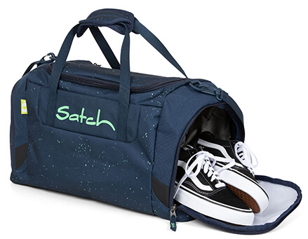 Eine Sporttasche der Marke satch ist an der rechten Seite geöffnet. Aus der Seitentasche ragen schwarz weiße Turnschuhe hervor.