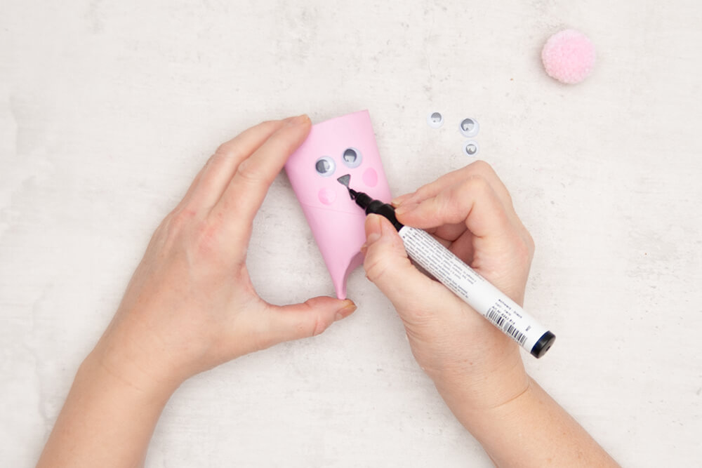 Wackelaugen werden auf eine Rosa bemalte Klopapierrolle aufgeklebt und ein Hasen-Gesicht mit einem Hobbymarker in schwarz aufgemalt. Fotos: Johanna Rundel