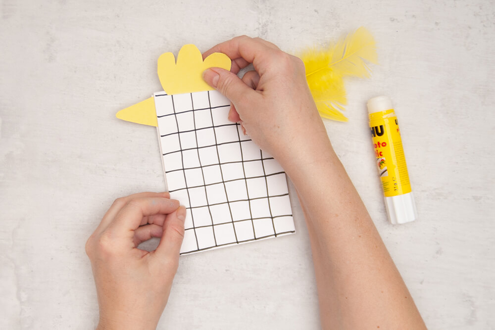 Ein gelber Schnabel, Kamm, sowie echte Federn von Heyda als Schwanz, werden an eine Papiertüte von Knorr-Prandell geklebt. Nun sieht sie aus wie ein Huhn. Fotos: Johanna Rundel