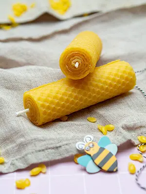 Zwei aus Bienenwachsplatten von KNORR prandell gerollte Kerzen liegen übereinander drapiert auf einem naturfarbenen Leinentuch. Foto: Johanna Rundel