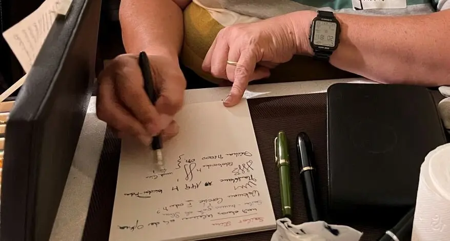 Jemand testet verschiedene Füllfederhalter in einem Notizbuch.