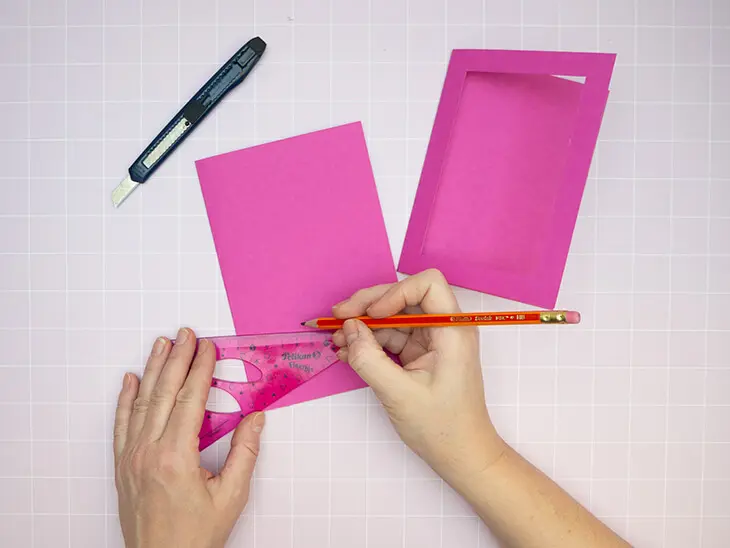 Jemand zeichnet mit einem Bleistift von herlitz ein Passepartout auf eine Klappkarte. Foto: Johanna Rundel