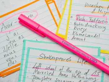 Ein Triplus-Textsurfer in Neonpink von STAEDTLER liegt auf einem Bett aus Lernkarten zur Vorbereitung von Klassenarbeiten. Foto: Johanna Rundel