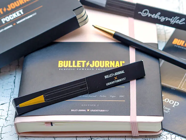lle Produkte der Bullet Journal Edition von LEUCHTTURM1917 liegen auf einer hellen Oberfläche verteilt: Bullet Journal, Drehgriffel, Pocket und Pen Loop. Foto: Johanna Rundel