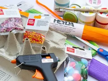 Viele verschiedene Bastelmaterialien von HEYDA und KNORR prandell liegen kreuz und quer auf einer hellen Unterlage. Foto: Johanna Rundel