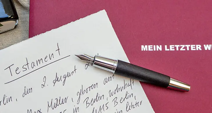 Ein hochwertiger Füller von Faber-Castell liegt auf einer roten Dokumentenmappe mir der Aufschrift: „Mein letzter Wille“. Daneben liegt ein handschriftliches Testament. Foto: Johanna Rundel