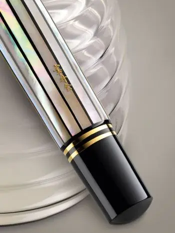Das untere Teil eines Pelikan Souverän Füllers aus der Limited Edition „Raden White Ray“ mit weißem Muschel-Intarsien und goldenen Akzenten