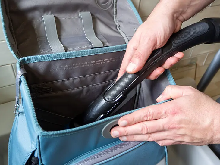 Jemand saugt das Innere eines blauen Schulranzens von School Mood mit einem Staubsauger aus. Foto: Johanna Rundel)