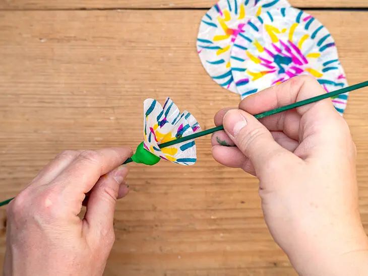 Jemand steckt mit einem Schaschlik-Spieß von KNORR prandell bunte Strohseide-Kreise in eine Kugel Kinderknete von HEYDA. Foto: Johanna Rundel