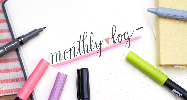 Auf einer Seite in einem aufgeschlagenen Bullet Journal steht in einer schönen Schreibschrift „monthly log“. Drumherum liegen verschiedene Stifte von Tombow. Foto: Johanna Rundel