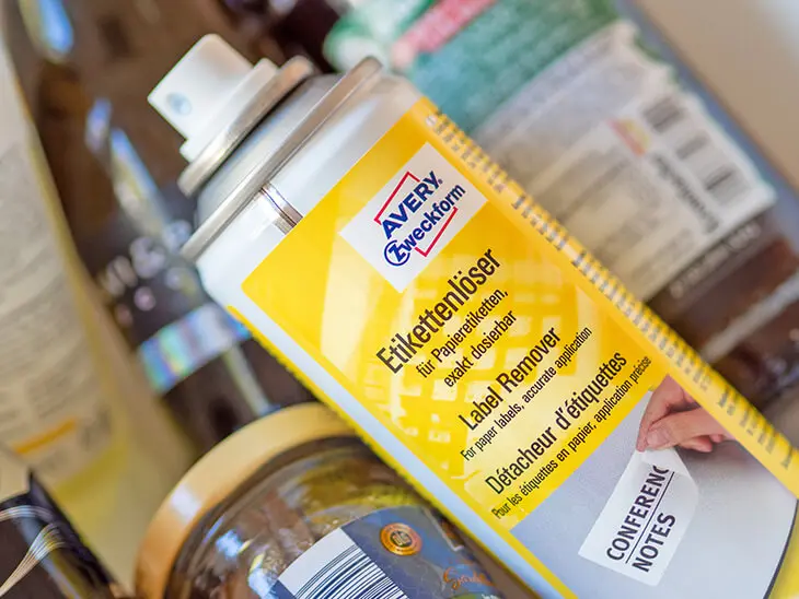 Eine Sprühdose Etikettenlöser von Avery Zweckform liegt in einer Schüssel mit Glasflaschen. Foto: Johanna Rundel