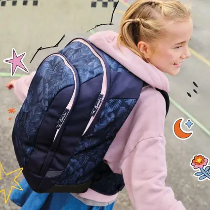 Ein Mädchen hält lächelnd eine Filmklappe über ihrem Kopf, im Hintergrund klettern Kinder auf einem Stahlgerüst.air auf ihrem Kopf.