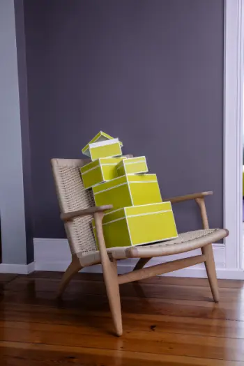 Grüne Fotoboxen unterschiedlichen Größen von Semikolon in stapeln sich auf einem Sessel.