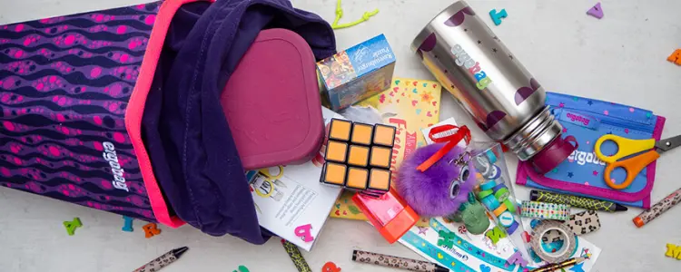 Aus einer geöffneten Schultüte fallen viele bunte Schulutensilien heraus