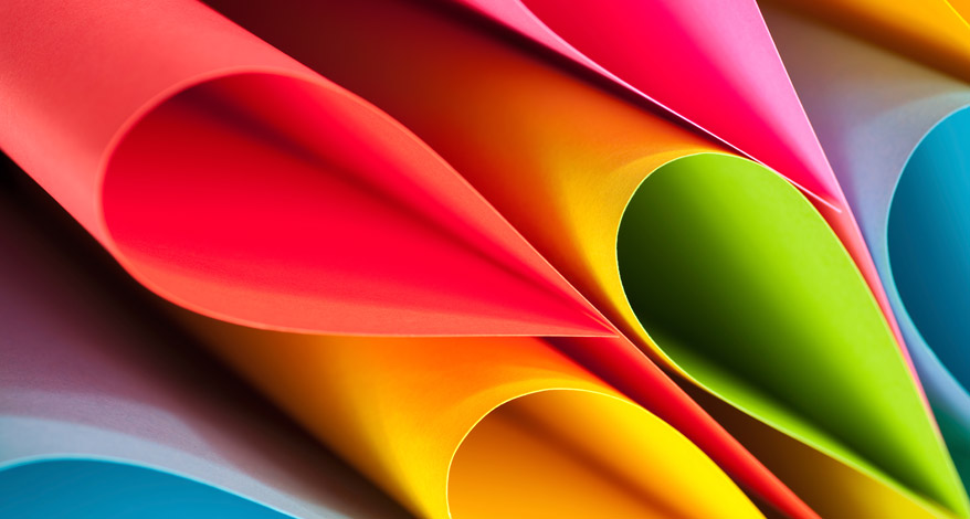 Hände falten einen DIN A4-Papierbogen Artoz in der Länge, um daraus eine Laterne aus Papier herzustellen.