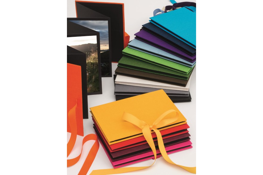 Foto-Leporellos in diversen Farben der Marke Semikolon liegen auf einem Tisch.