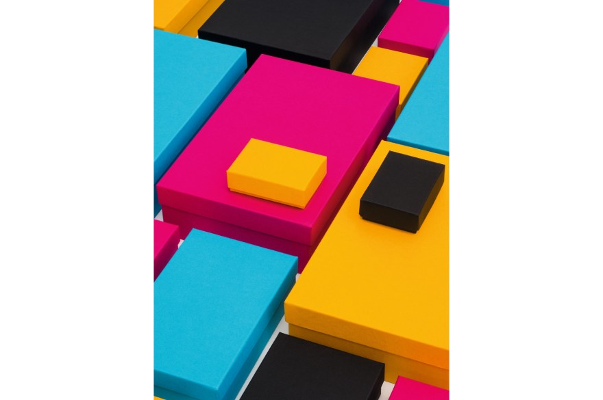 Bunte Kartonagen in unterschiedlichen Größen der Marke Semikolon liegen auf einem Tisch.