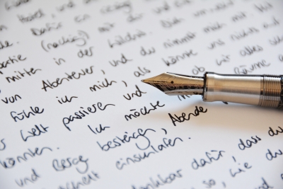 Nahaufnahme eines Ausschnitts eines mit Hand geschriebenen Briefes. Man sieht die Spitze eines Füllers, der auf dem Brief liegt.